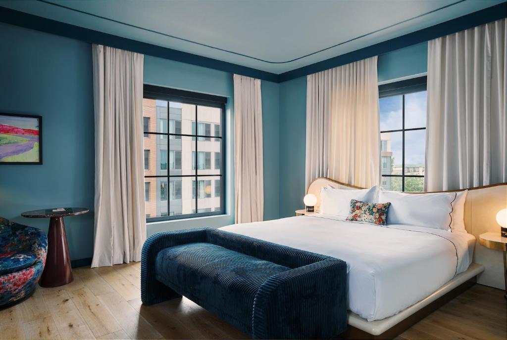 路易斯威尔Hotel Genevieve的卧室配有白色的床和2扇窗户。