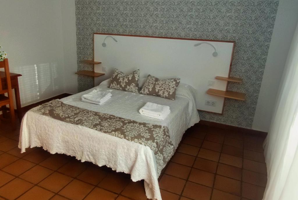 瓜达卢佩阿尔塔米拉瓜达卢佩旅馆的一间卧室配有一张带两个枕头的床