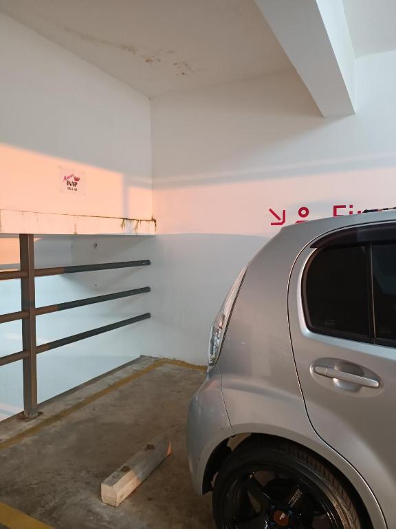 关丹Timurbay Seafront Residence Mawar Inap Homestay的把车停在车库里,上面写着你在墙上租用的字眼