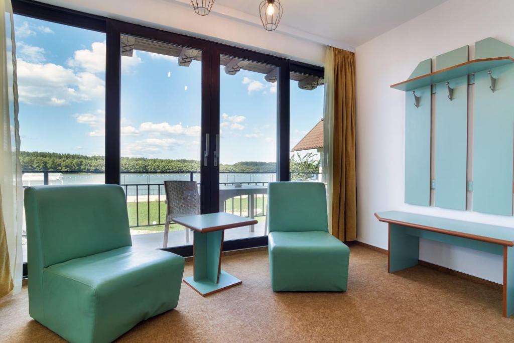 Băltenii de SusAmore Resort的一间等候室,配有两把椅子、一张桌子和大窗户