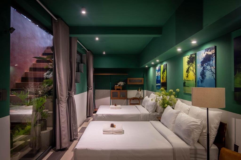 大叻The Note Dalat的一间设有两张床和绿色墙壁的客房