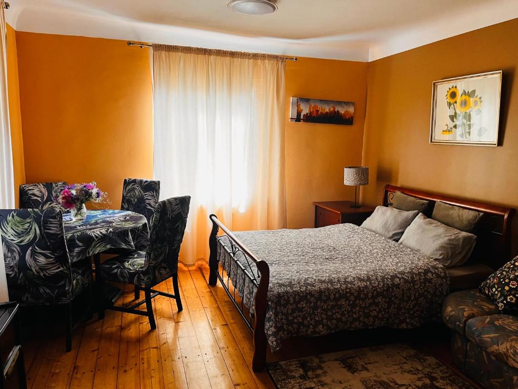 里加Unique Mailo cottage的一间卧室配有一张床、一张桌子和一个窗户。