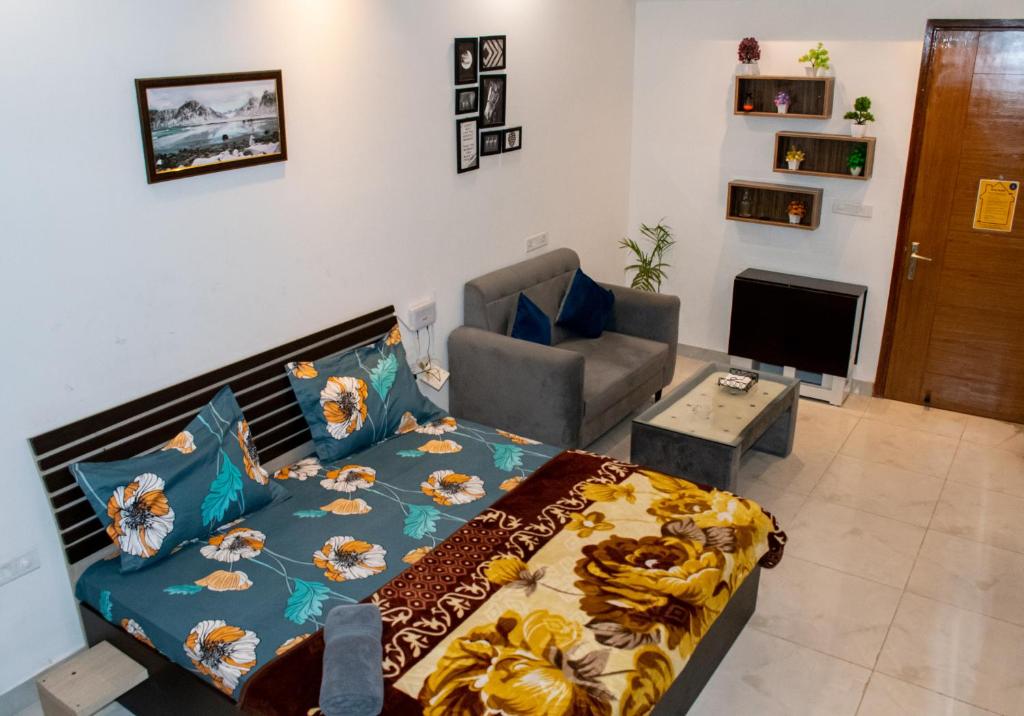 诺伊达The Forest Stays-Luxury Studio Apartment In Noida的一间卧室配有一张床、一张沙发和一把椅子