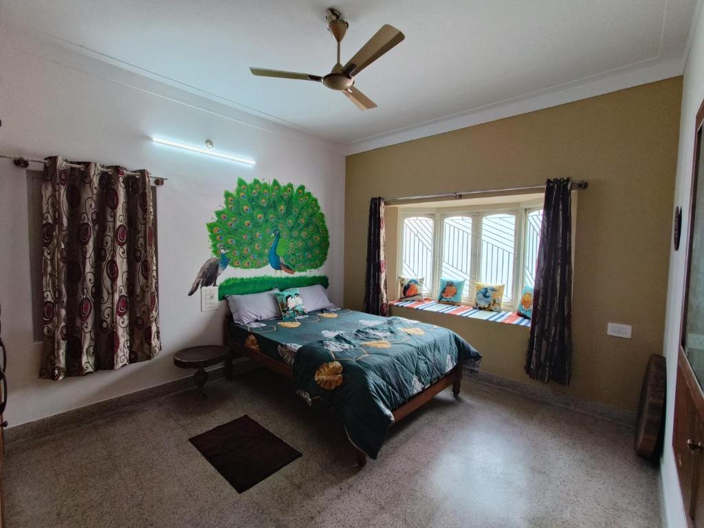 迈索尔Tusker Tribe的卧室配有一张床铺,墙上挂着一棵树