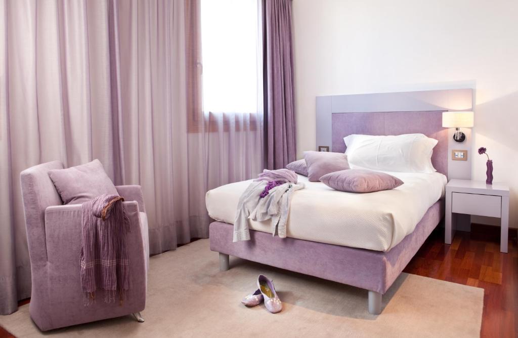 坎波桑皮耶罗阿尔特佐酒店的一间卧室配有一张大床和一把椅子