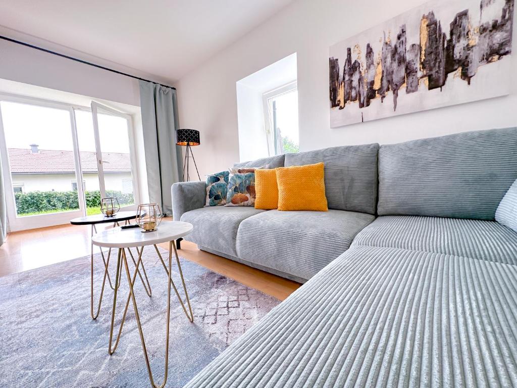 巴特格莱兴贝格Idyllische Wohnung mit Garten!的客厅配有灰色的沙发和桌子