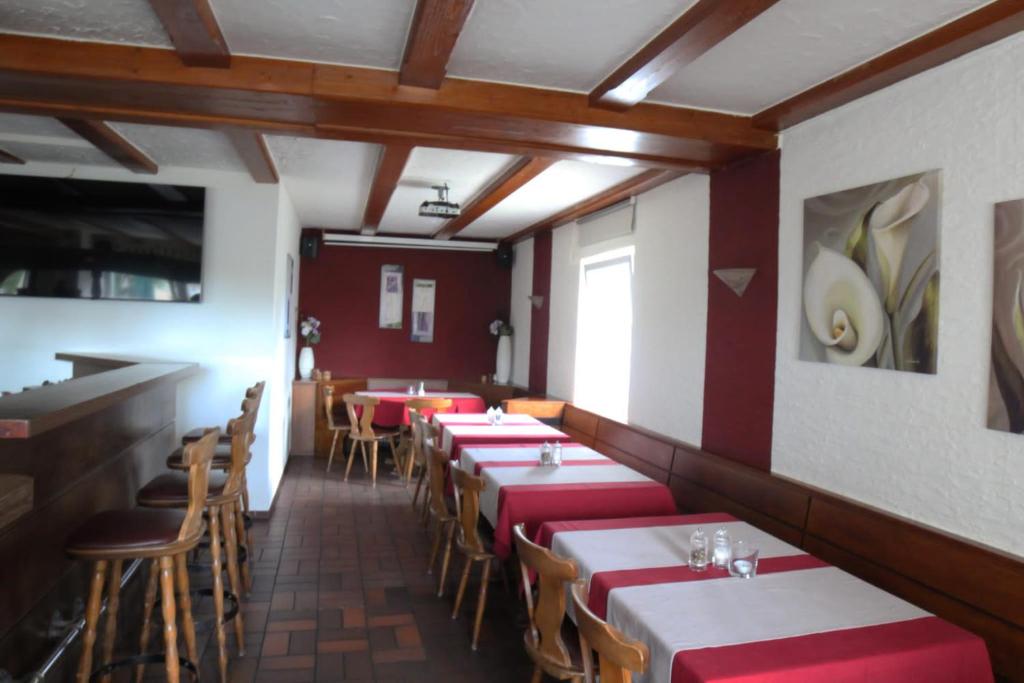 黑措根奥拉赫Altes Backhaus的餐厅设有红色和白色的桌椅