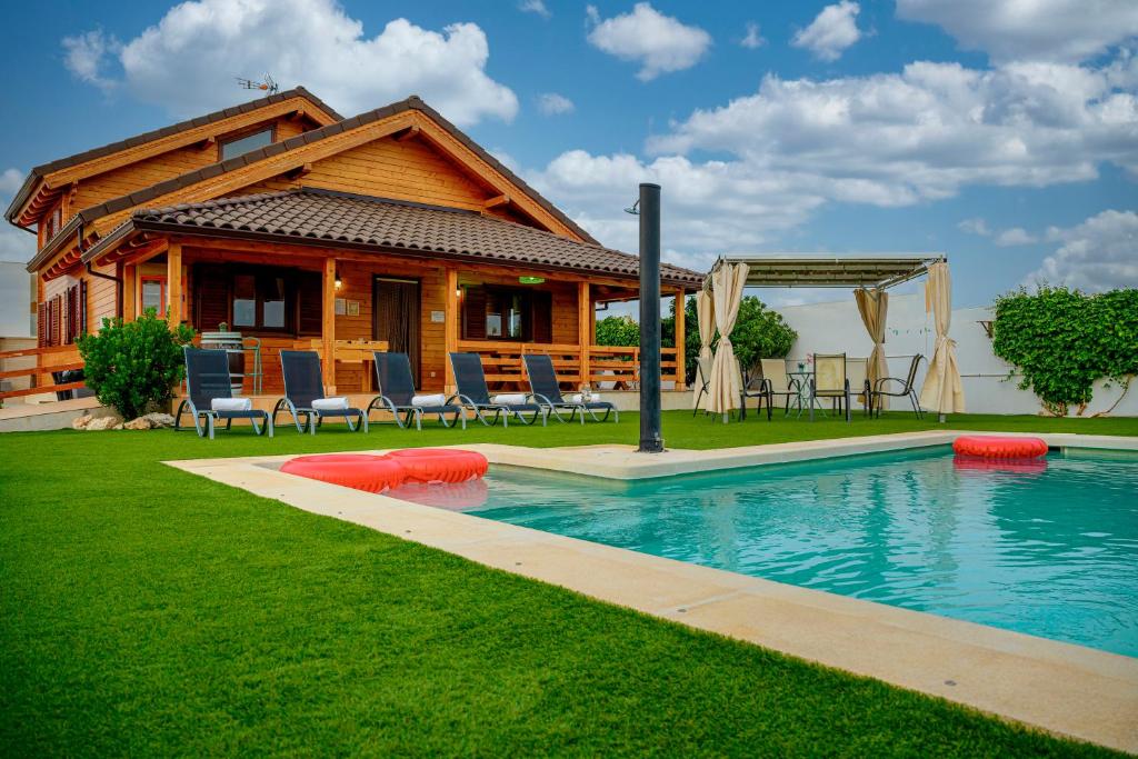 GuadamurMadera y Miel Casa Rural con niños en Puy du Fou的庭院中带游泳池的房子