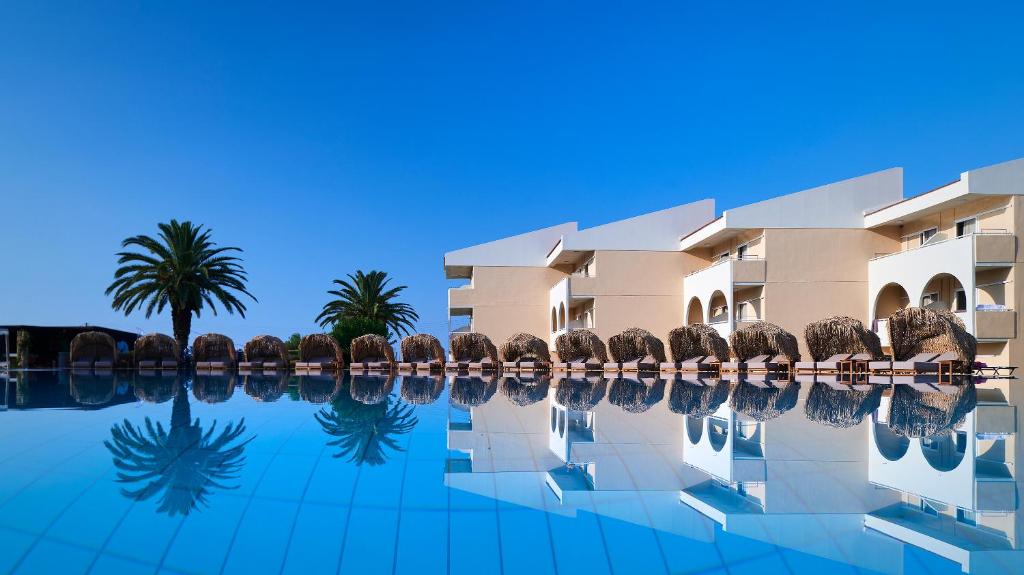 里科索翁Argile Resort & Spa的一座楼前棕榈树游泳池
