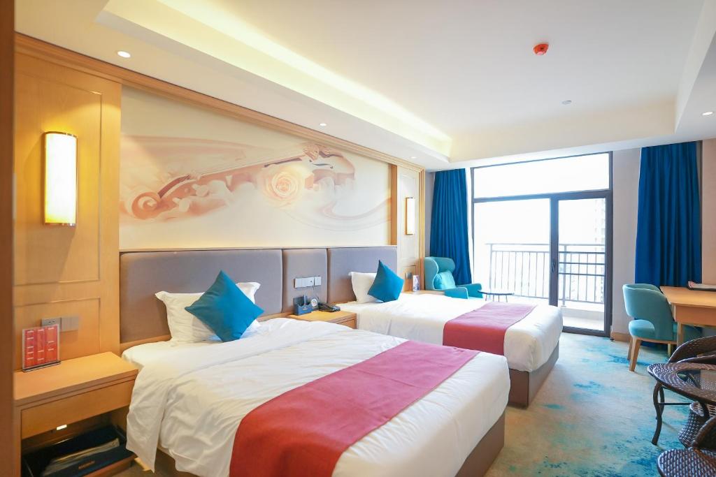 西哈努克SENNA SUNSHINE INTERNATIONAL HOTEL的酒店客房配有两张床和一张书桌