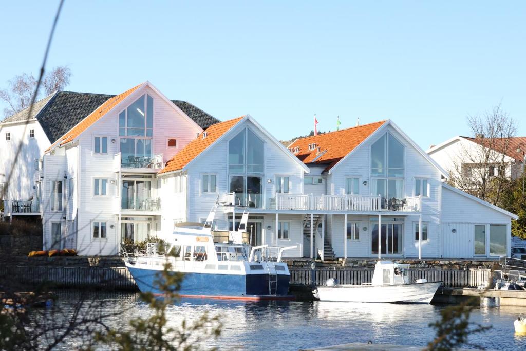 Østhusvik布利斯峡湾酒店的一群水中装有船的房屋