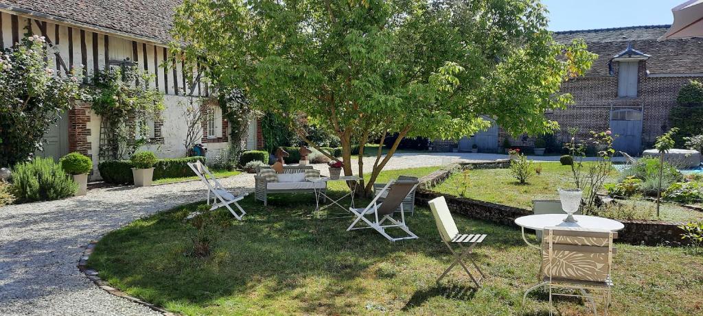 MousseyDomaine de la Creuse的一个带椅子和桌子的院子和一棵树