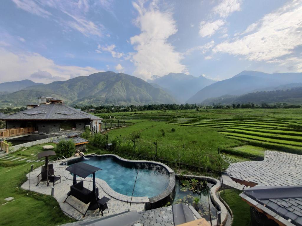 康格拉Osho Himalayas Wellness Resort的享有带游泳池的度假村的空中景致