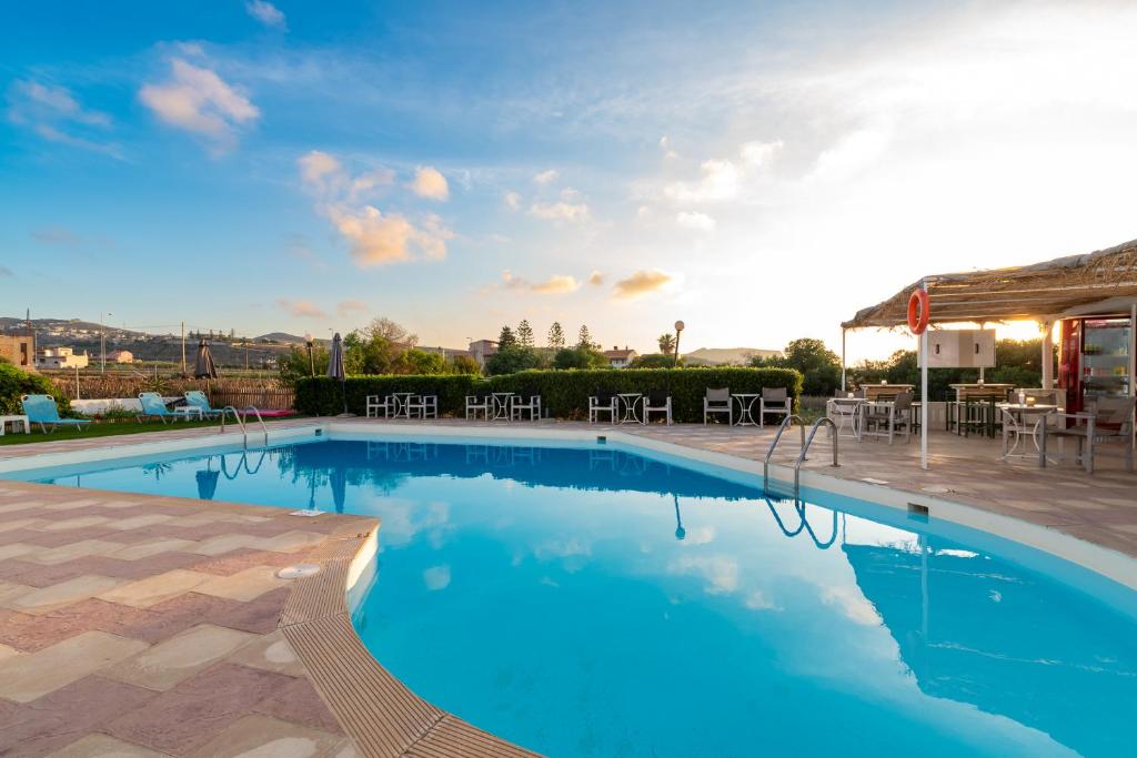 库基尼坎尼奥Anemos Inn by Estia的大型游泳池,带桌椅的庭院