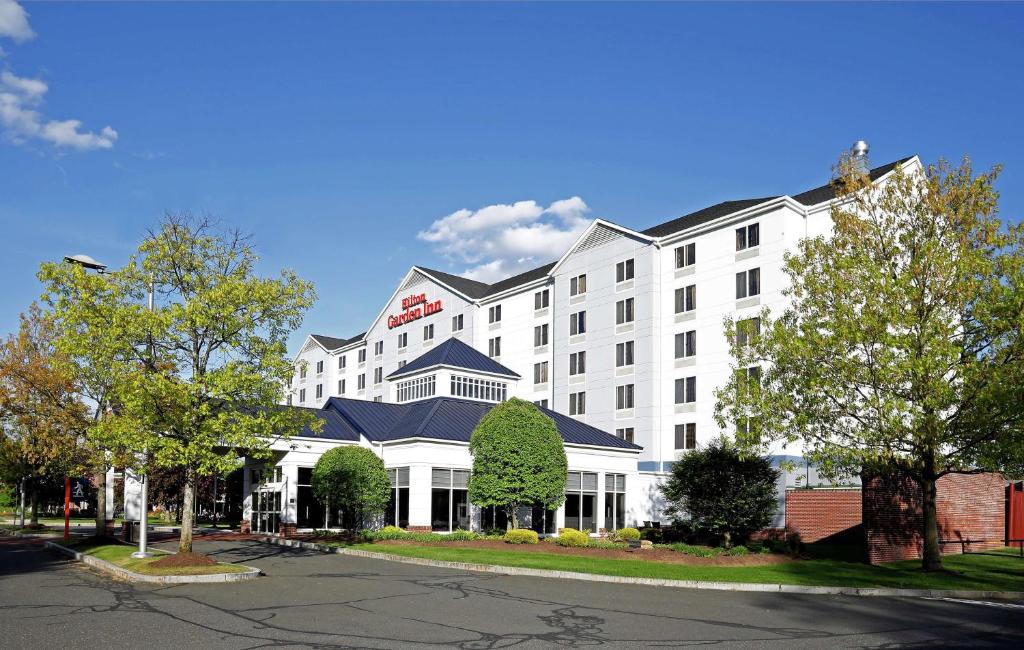 斯普林菲尔德Hilton Garden Inn Springfield, MA的白色的酒店建筑,拥有蓝色的屋顶