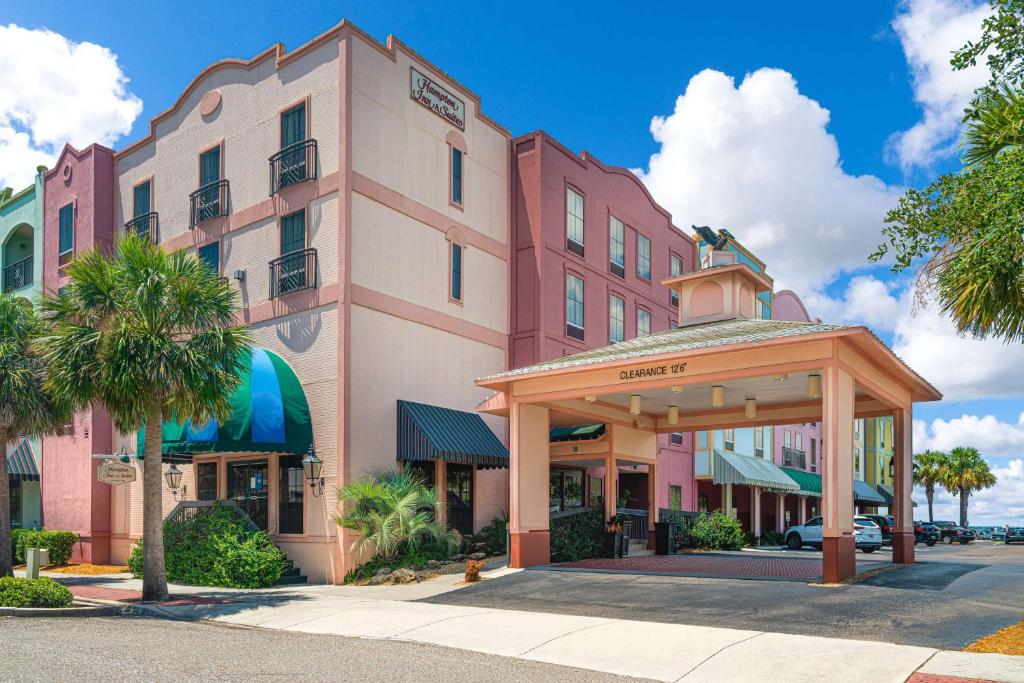 费南迪纳比奇Hampton Inn & Suites Amelia Island-Historic Harbor Front的一座大型粉红色建筑,前面设有一个凉亭