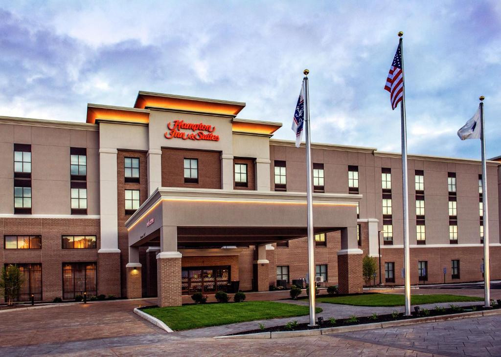 福克斯伯勒Hampton Inn & Suites/Foxborough/Mansfield的前面有两面美国国旗的酒店