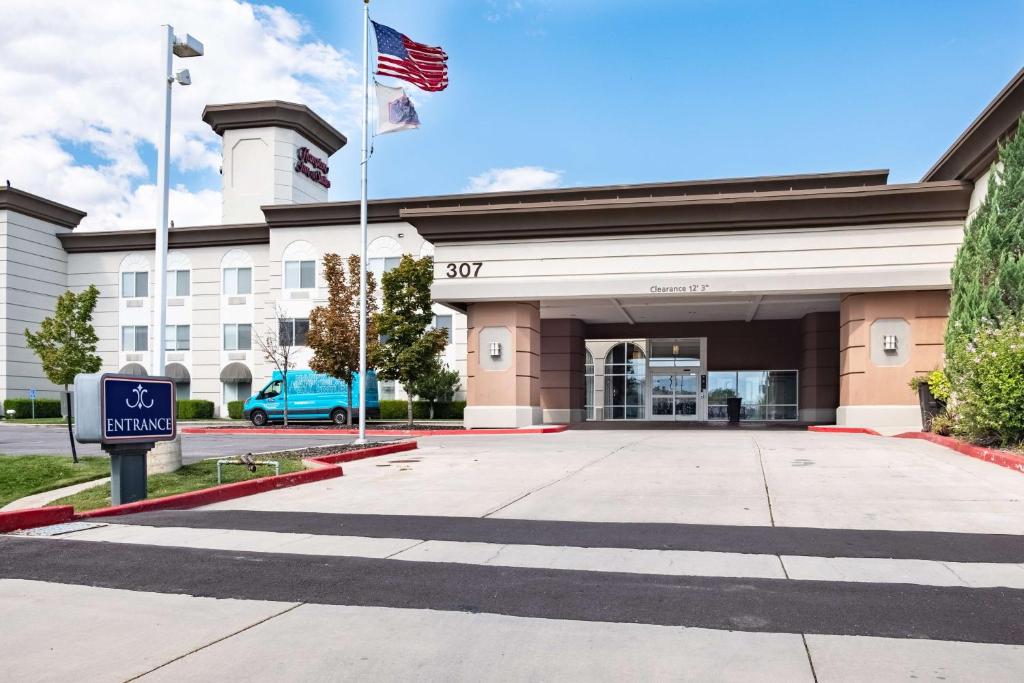 盐湖城盐湖城机场汉普顿套房酒店的前面有美国国旗的建筑