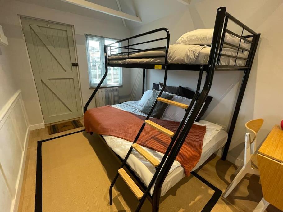 KentMerryfield Lodge的带两张双层床和一扇门的房间