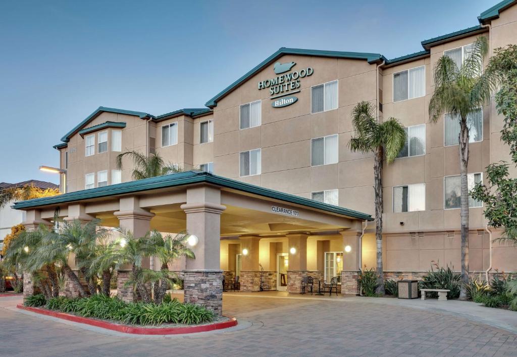 圣地亚哥圣迭戈德尔马希尔顿惠庭套房酒店的一座酒店大楼前面有棕榈树