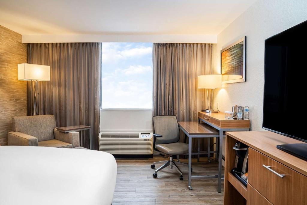 基奇纳DoubleTree by Hilton Kitchener的酒店客房配有一张床、一张书桌和一台电脑