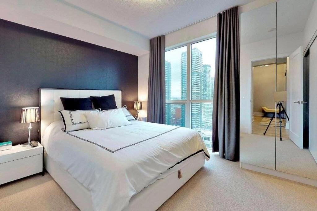 多伦多Residence Inn by Soho的卧室设有一张白色大床和大窗户