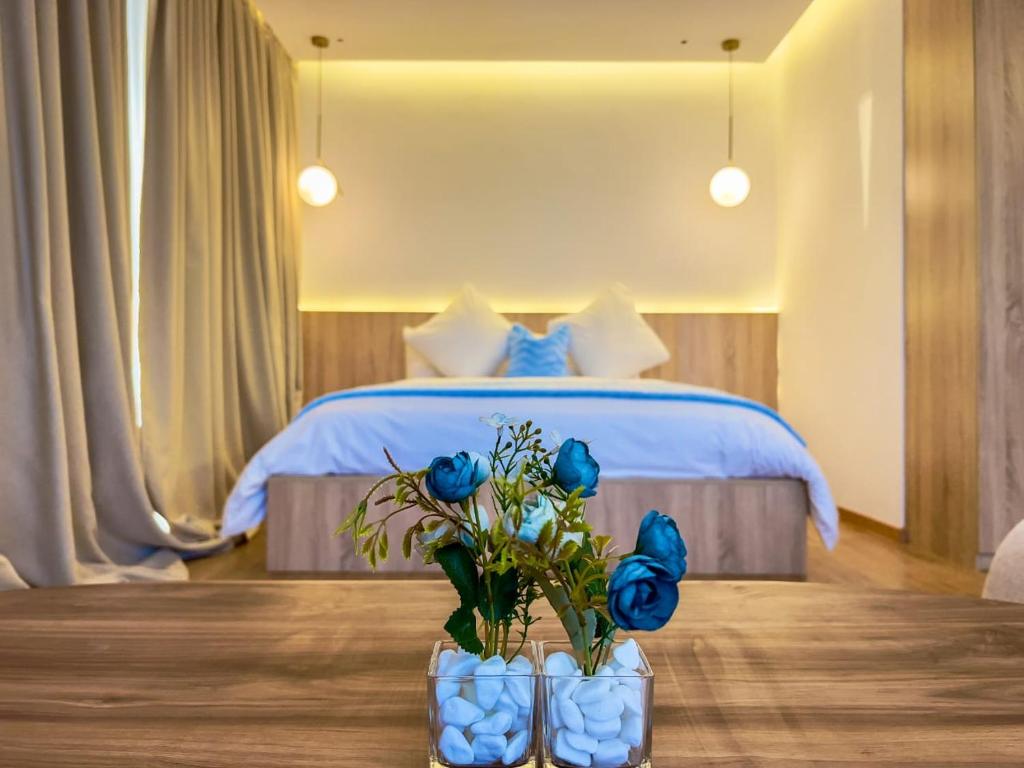 杰迪代Les Roches De Mazagan的一间卧室配有一张桌子上的蓝色玫瑰床