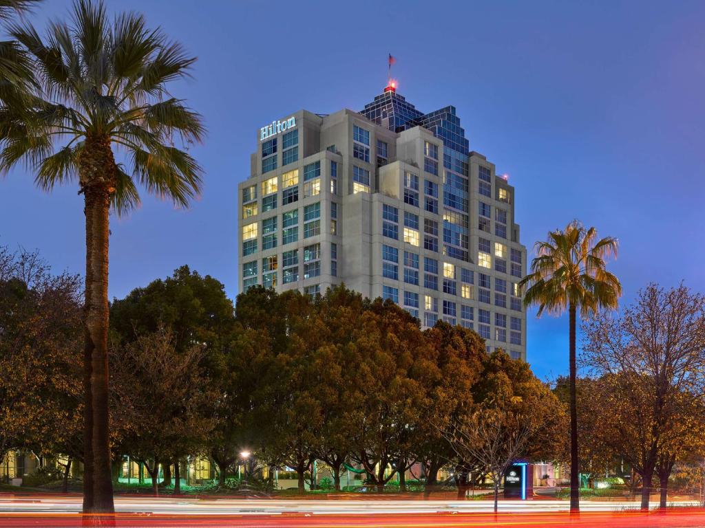 格伦代尔北洛杉矶格伦代尔行政会议中心希尔顿酒店的一座高大的建筑,前面有棕榈树