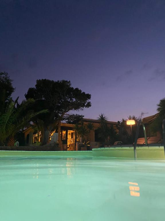 兰佩杜萨Hotel Luagos club的游泳池,后方是一座房子