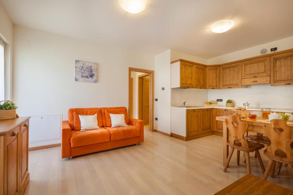 科马诺泰梅卡萨莱公寓的厨房里摆放着橙色的沙发,配有桌子