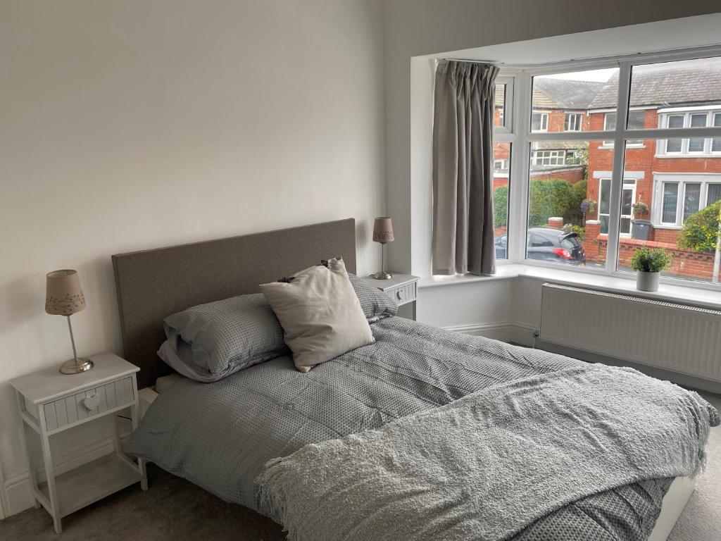 布莱克浦Richards Retreat Blackpool的卧室配有带枕头的床铺和窗户。