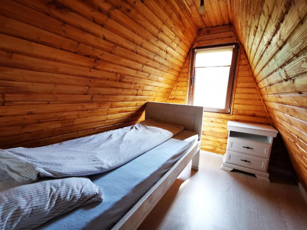 CărbunariLivada Becica的木制客房的一张床位,设有窗户