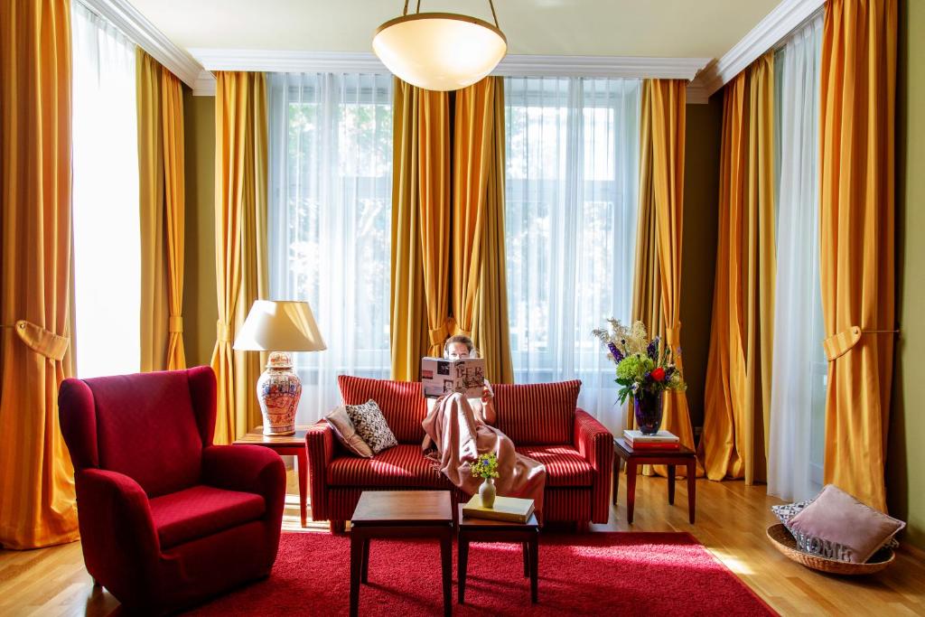 柏林路易莎故居酒店的客厅配有红色椅子和红色地毯