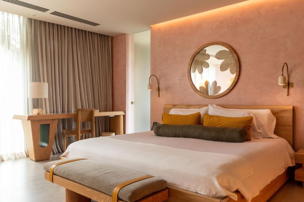 麦德林23 Hotel Medellin的一间卧室配有一张大床和镜子