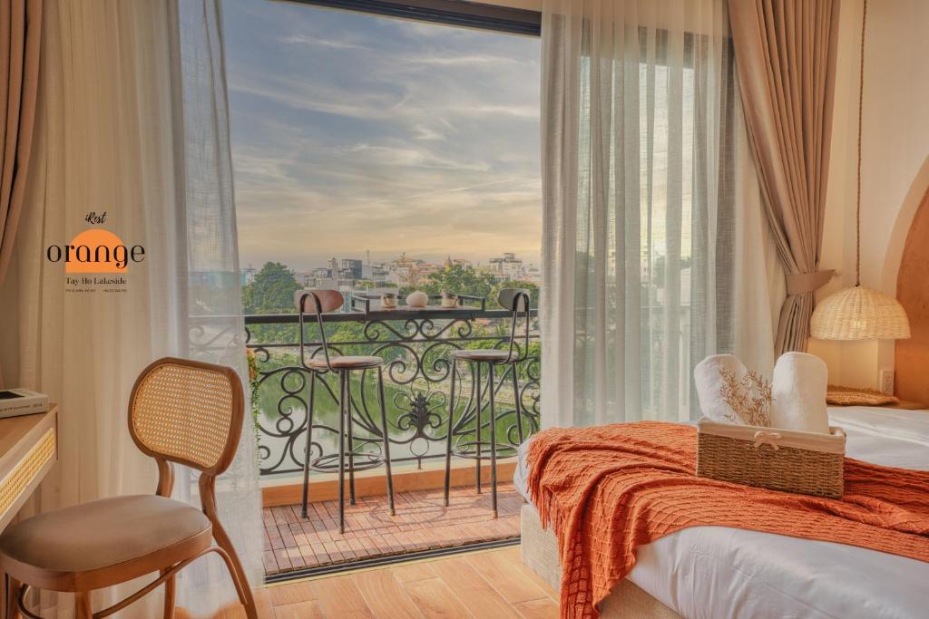 河内iRest Orange Tay Ho Lakeside Apartment的卧室设有1个带1张床和1扇大窗户的阳台
