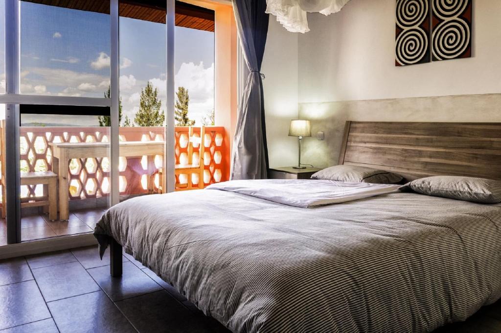 基加利5瑞士酒店的一间卧室设有一张床和一个大窗户