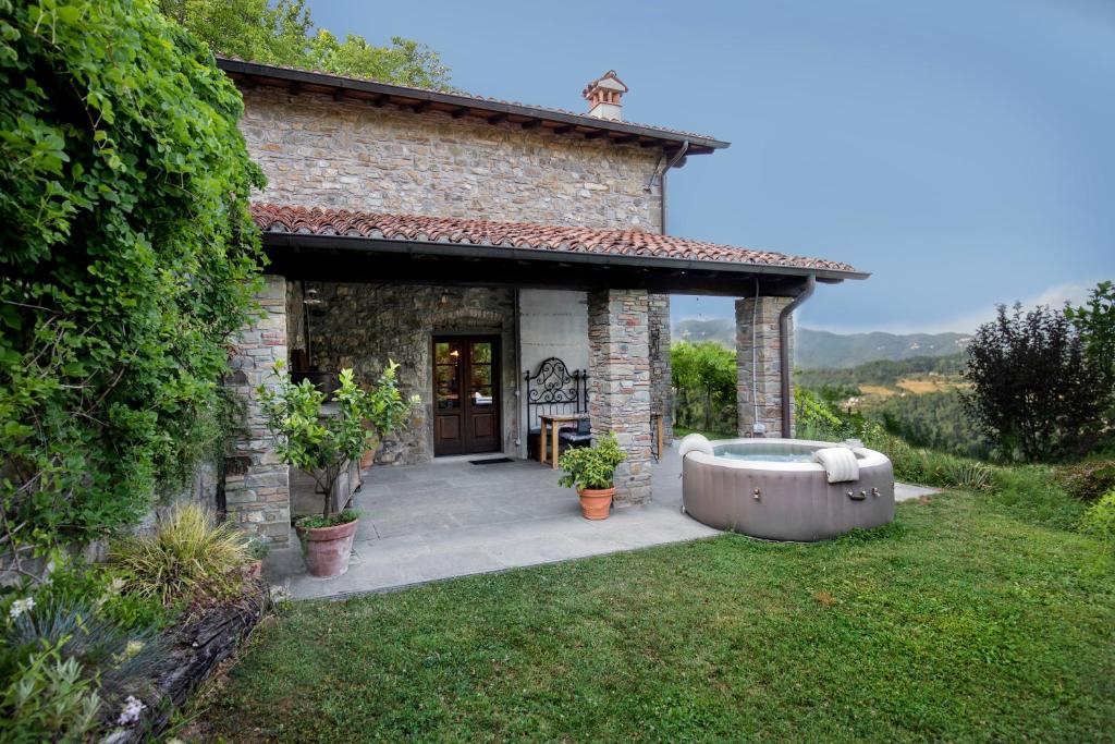 PoggioBirillina Guest House di Laura Reni的庭院内带浴缸的小型石头房子