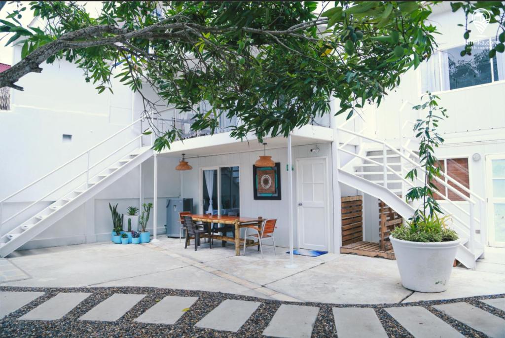 卡塔赫纳Blue Sand House B&B的白色的房子,设有楼梯和桌子
