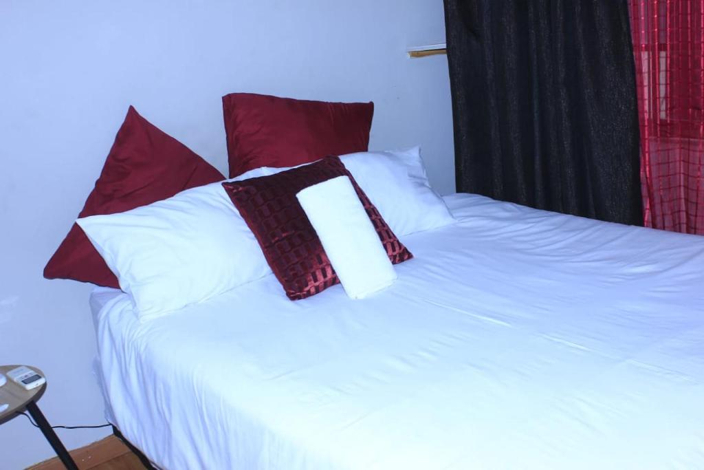 恩潘盖尼Sun & Night的白色的床和红色和白色的枕头