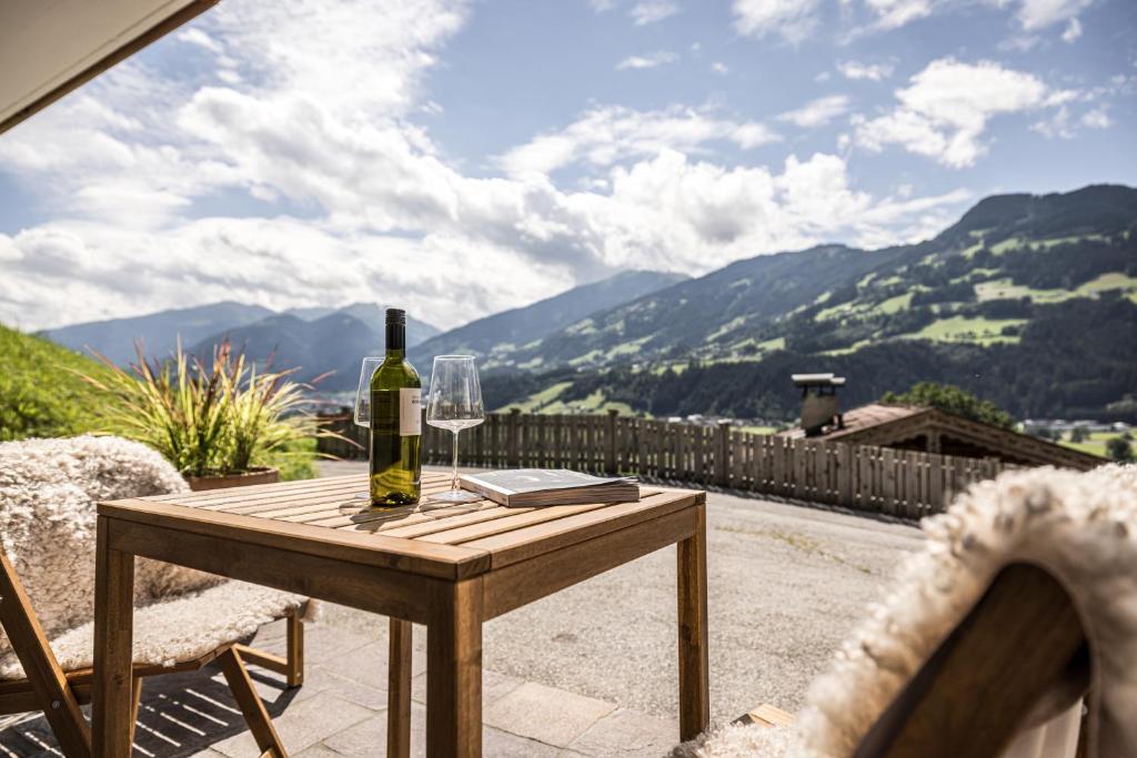奇勒谷地哈特VIEW4TWO / Chalet-Apartment Zillertal的庭院木桌旁的一瓶葡萄酒