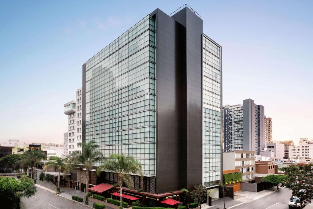 利马DoubleTree by Hilton Lima Miraflores El Pardo的一座高大的建筑,在城市里装有玻璃窗