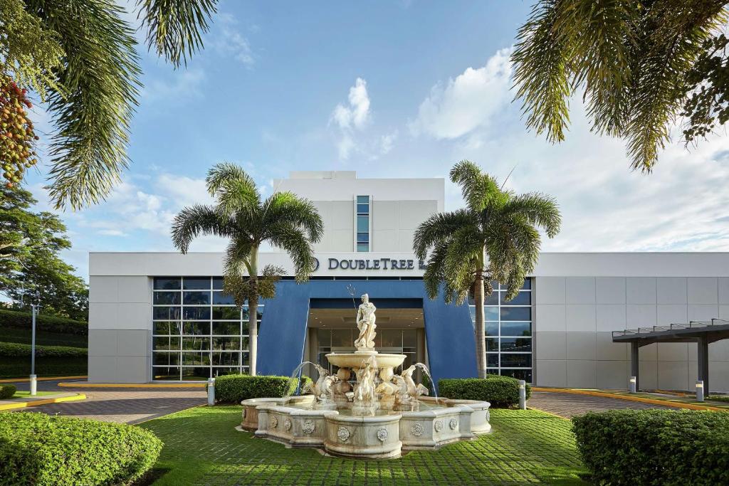 马那瓜DoubleTree by Hilton Managua的棕榈树建筑前的喷泉