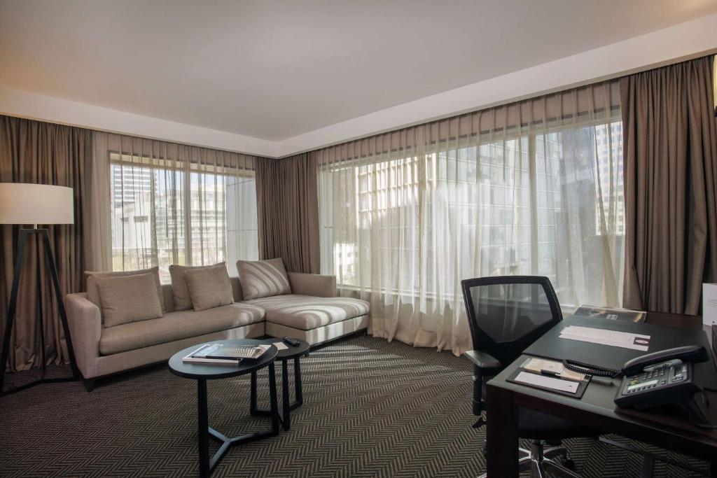 圣地亚哥圣地亚哥 - 比塔库拉希尔顿逸林酒店的客厅配有沙发和桌子