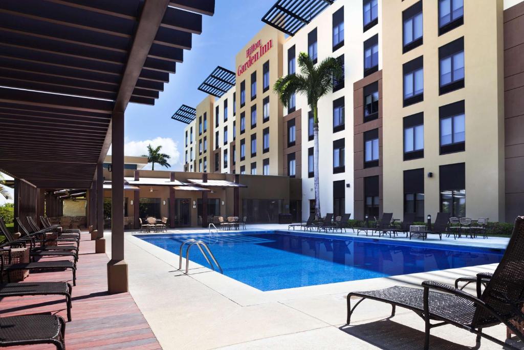 利比里亚Hilton Garden Inn Guanacaste Airport的一座酒店庭院内的游泳池