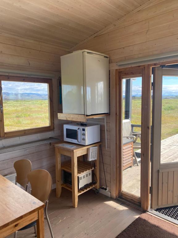 海拉Log house with a view - Bjalki的一间小屋内配有微波炉和桌子的房间