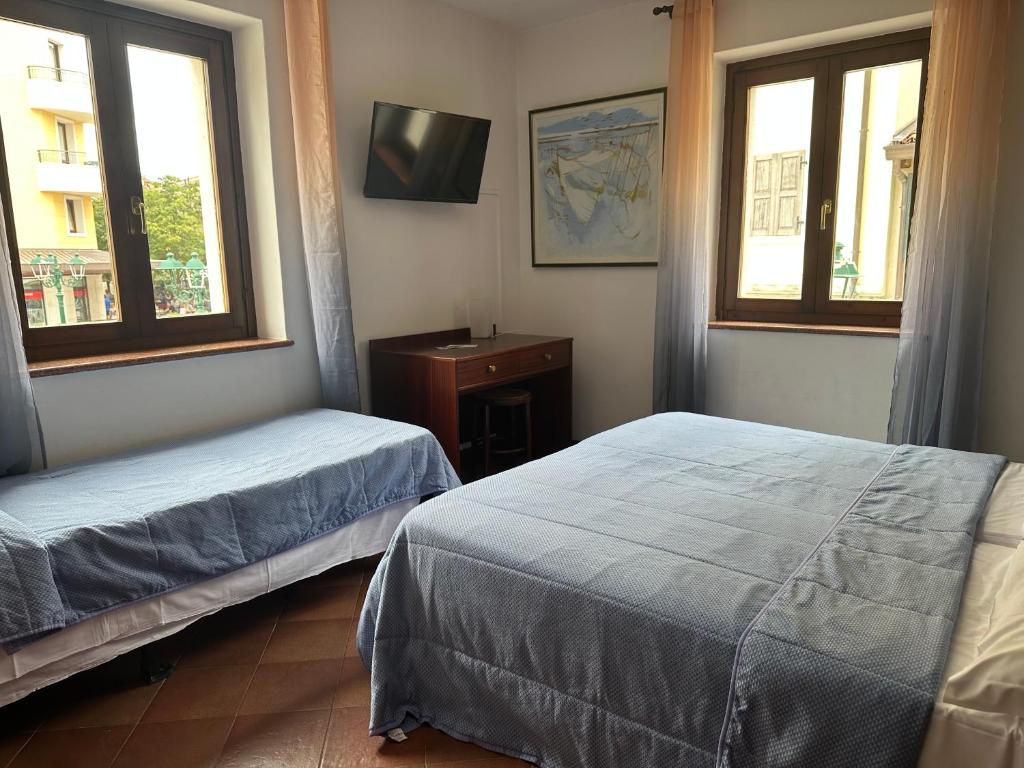 格拉多阿拉齐塔迪特里雅斯特酒店的一间卧室设有两张床,墙上配有电视。