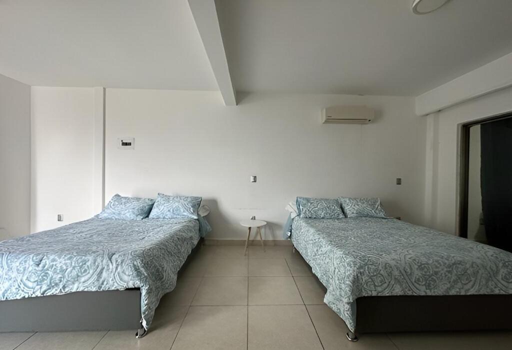 图斯特拉古铁雷斯Casa moderna climatizada en Tuxtla Gutiérrez的一间卧室配有两张床和一张桌子