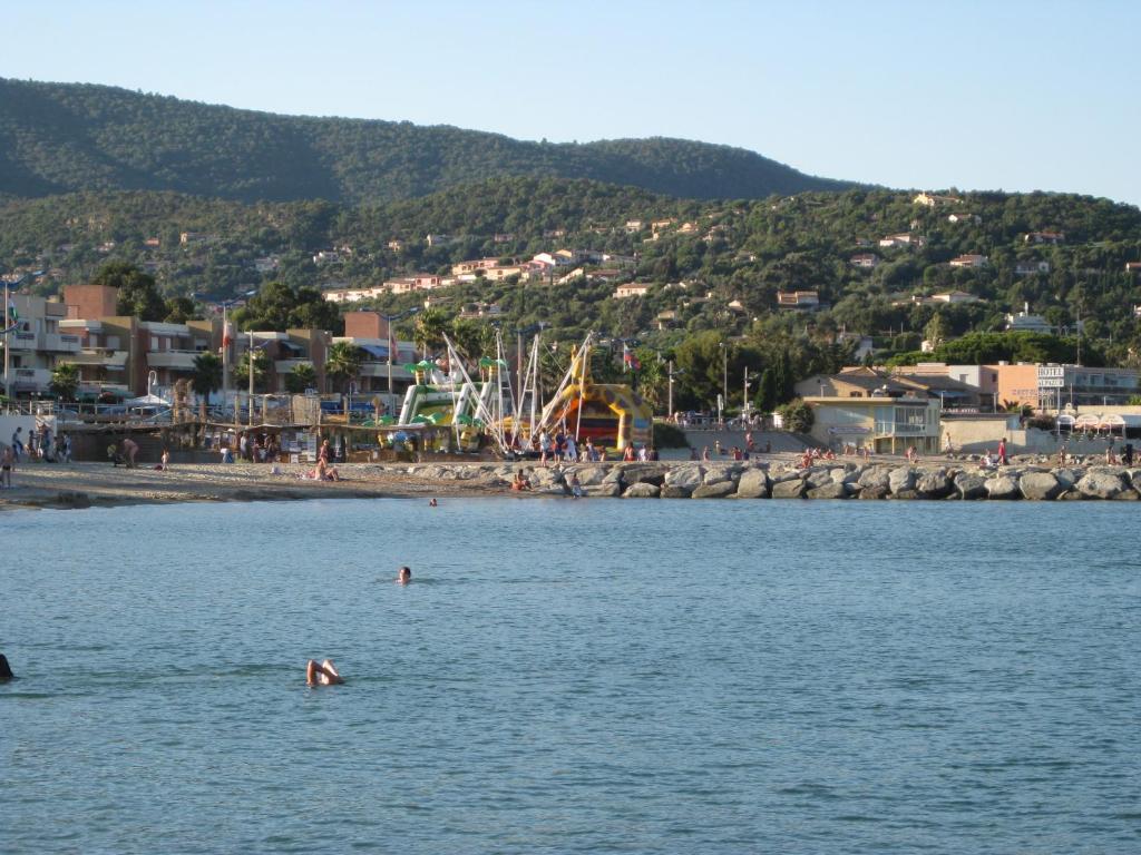 滨海卡瓦莱尔Rez de villa, 2 pièces, 2 à 4 pers, à 250 m plage et centre-ville的在海滩附近的水中游泳的人