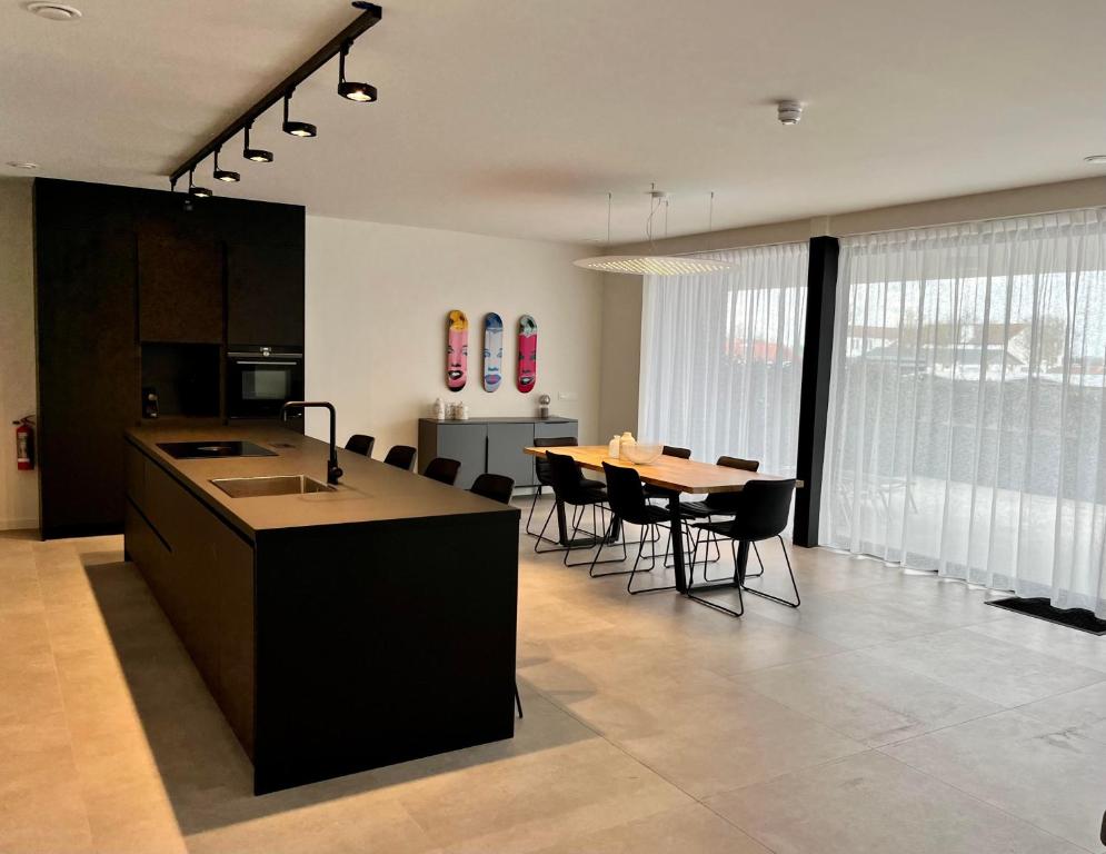 卡德赞德Design Apartment with 60m² terrace - heated inside pool and wellness facilities - very close to the beach的厨房以及带桌椅的用餐室。