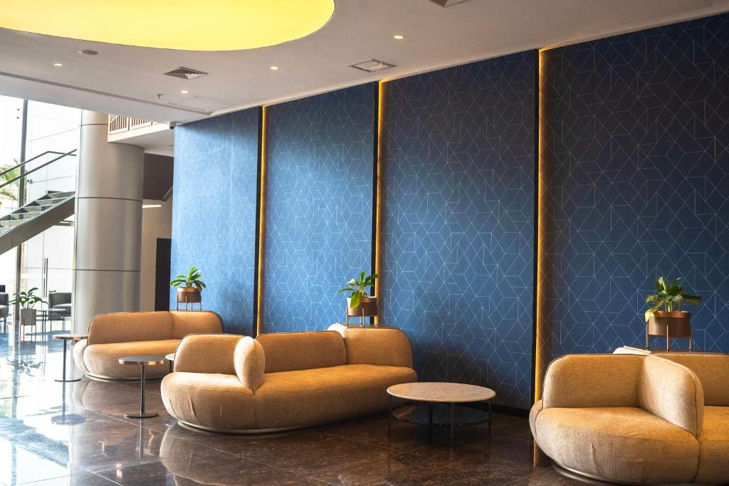 特鲁希略Doubletree By Hilton Trujillo的一个带沙发和蓝色墙壁的大堂